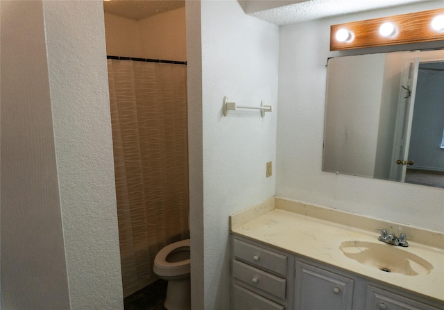 full bathroom featuring curtained shower, toilet, vanity, and a textured wall