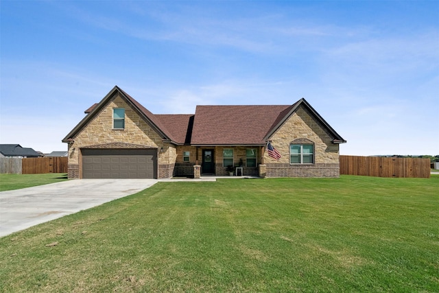 french country style house with a front yard, fence, concrete driveway, a garage, and brick siding