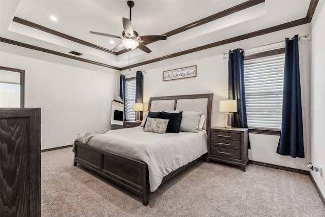 bedroom featuring visible vents, baseboards, a tray ceiling, ornamental molding, and light carpet