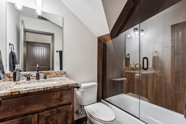 bathroom featuring enclosed tub / shower combo, toilet, vanity, and a textured wall