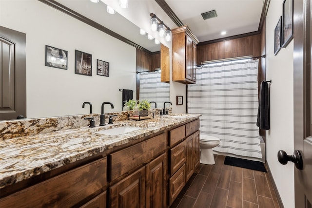 bathroom featuring double vanity, visible vents, wood finish floors, and a sink