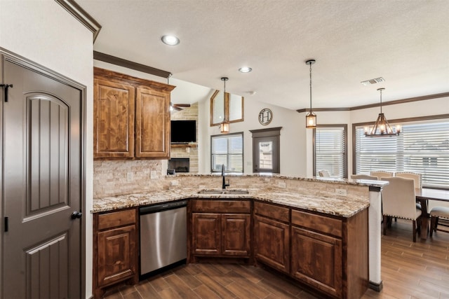 kitchen featuring visible vents, dishwasher, wood tiled floor, and a sink