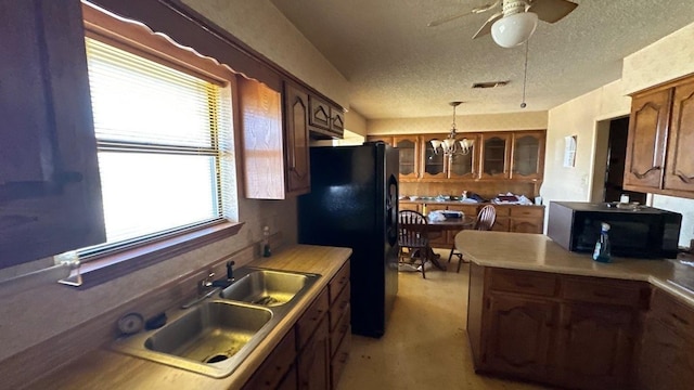 kitchen with visible vents, a sink, black appliances, glass insert cabinets, and a textured ceiling