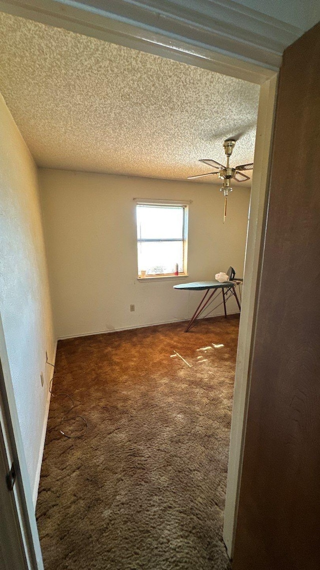 carpeted empty room with a textured ceiling and ceiling fan