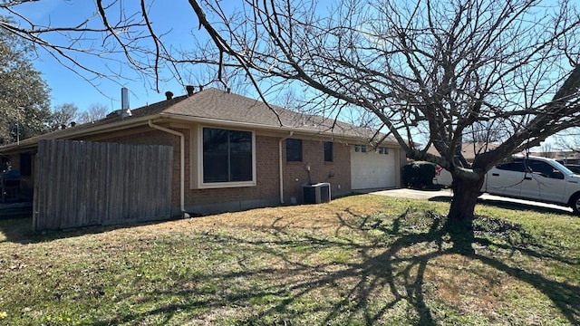 view of side of home with central air condition unit, brick siding, concrete driveway, and an attached garage