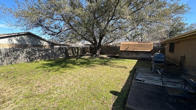 view of yard featuring an outbuilding, a storage shed, and a fenced backyard