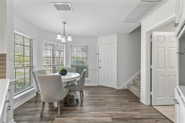 dining room with light wood-style floors, visible vents, and a wealth of natural light