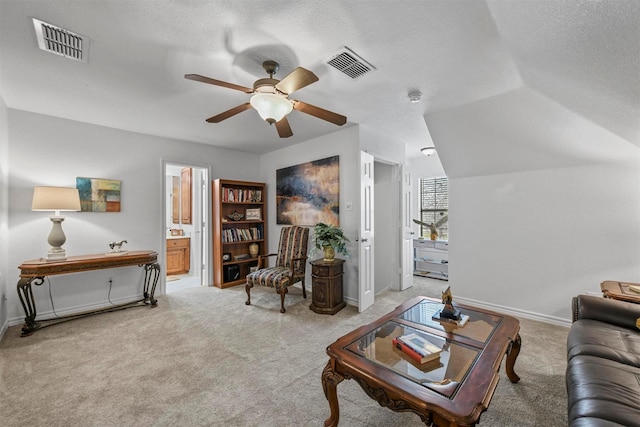 living room featuring carpet, visible vents, and a textured ceiling