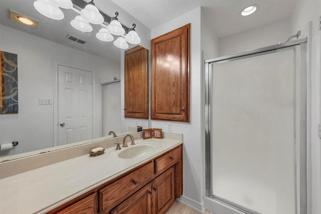 bathroom featuring vanity, visible vents, and a stall shower