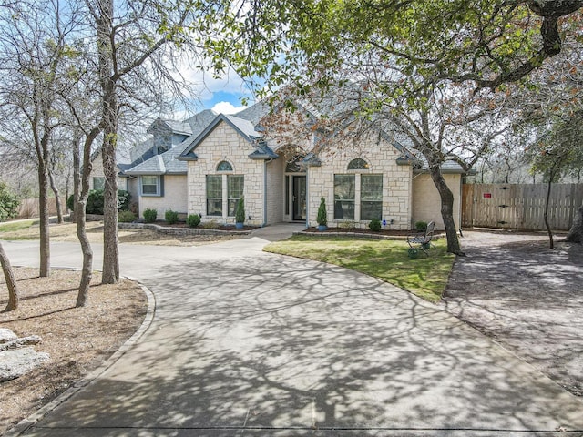 french provincial home featuring fence and driveway