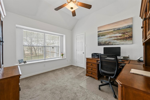 office with a ceiling fan, vaulted ceiling, light colored carpet, and baseboards