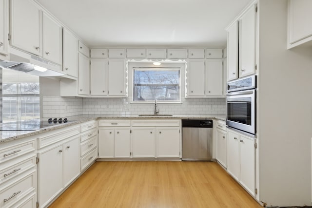 kitchen with a sink, stainless steel appliances, under cabinet range hood, and white cabinetry