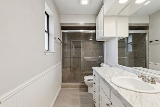 full bathroom with wainscoting, vanity, toilet, and a shower stall