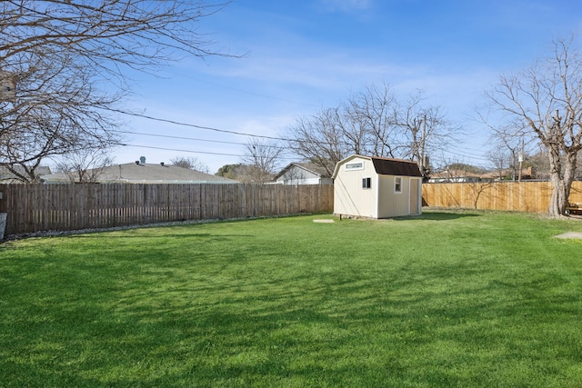 view of yard with a storage unit, an outbuilding, and a fenced backyard