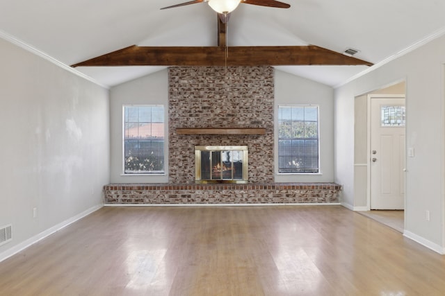 unfurnished living room with wood finished floors, plenty of natural light, a fireplace, and ornamental molding