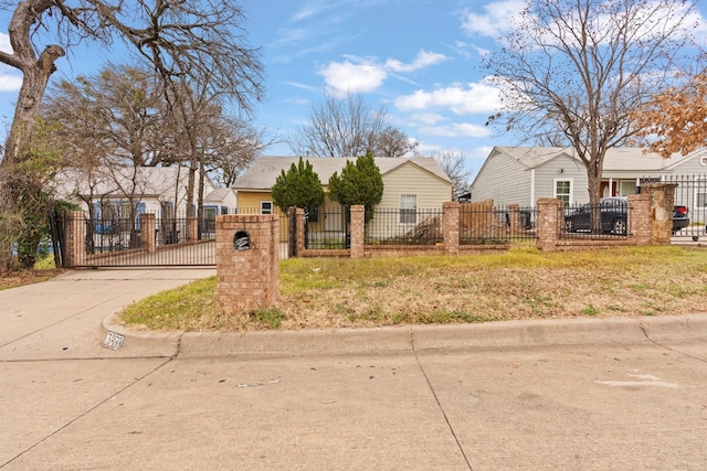 view of front facade with a fenced front yard, driveway, and a gate