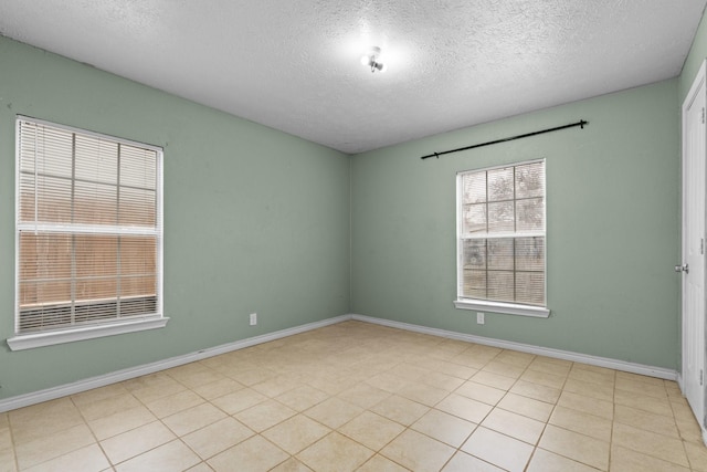 unfurnished room with a textured ceiling and baseboards