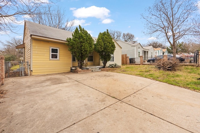 rear view of house with a gate, a shingled roof, and fence