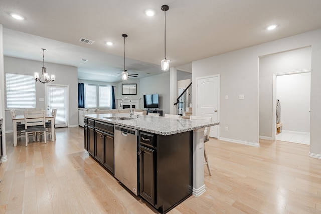 kitchen featuring visible vents, open floor plan, light wood-type flooring, stainless steel dishwasher, and a sink