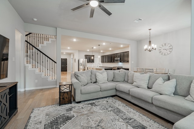 2304 Ravensway Rd, Crandall, TX 75114 - living room with light wood-style floors, ceiling fan, stairway, a chandelier, and recessed lighting