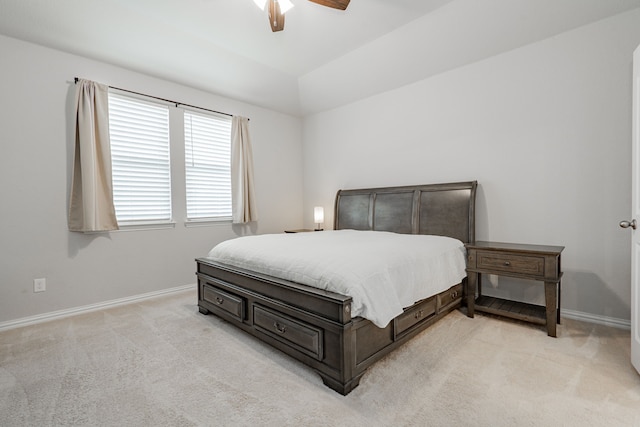 bedroom with light colored carpet, lofted ceiling, baseboards, and ceiling fan