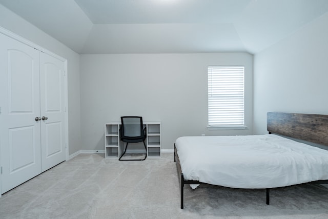 bedroom featuring baseboards, lofted ceiling, and light colored carpet