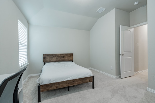 bedroom with light carpet, visible vents, baseboards, and vaulted ceiling