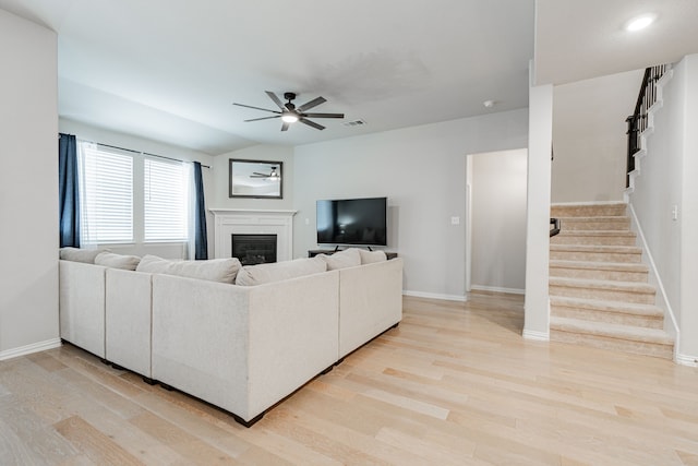 2304 Ravensway Rd, Crandall, TX 75114 - living area with ceiling fan, light wood-style floors, a glass covered fireplace, and stairs