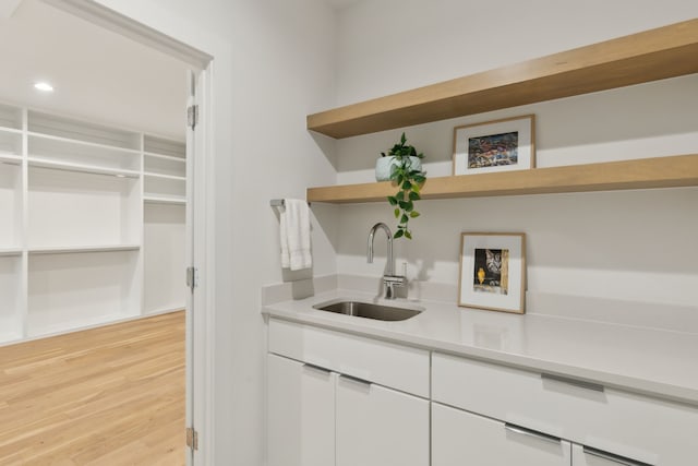 bar with a sink, light wood-style floors, and recessed lighting