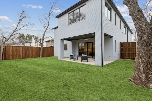 rear view of house featuring brick siding, a lawn, a patio, a fenced backyard, and a ceiling fan