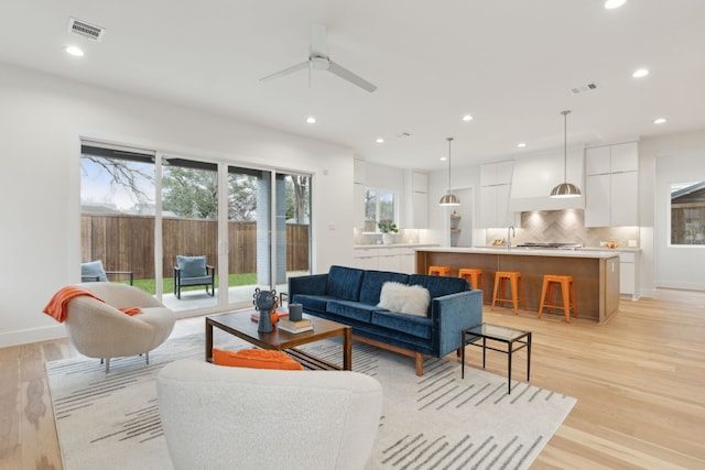 living room featuring recessed lighting, visible vents, baseboards, and light wood-style flooring