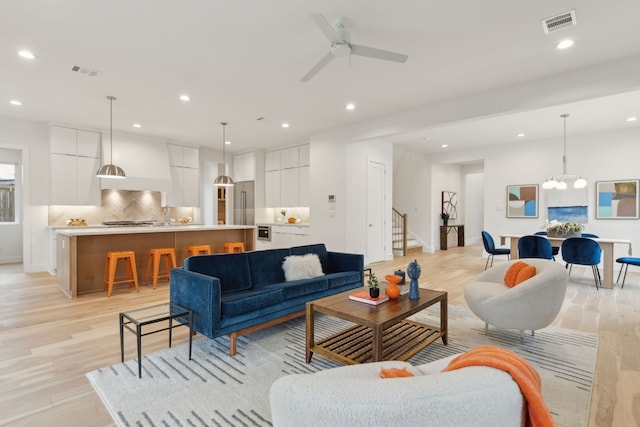 living area with recessed lighting, visible vents, and light wood finished floors