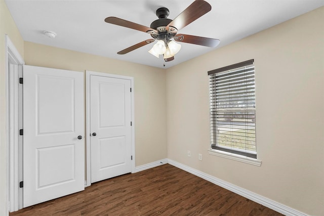 unfurnished bedroom featuring ceiling fan, baseboards, and wood finished floors