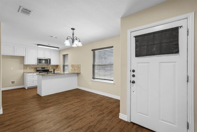 kitchen featuring visible vents, dark wood finished floors, a peninsula, white cabinets, and appliances with stainless steel finishes