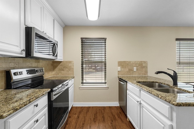 kitchen featuring white cabinets, stainless steel appliances, dark wood-type flooring, and a sink