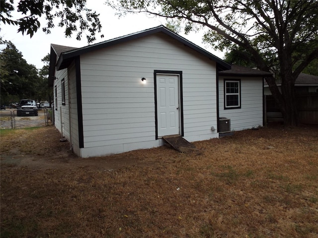view of outbuilding with central AC unit and fence