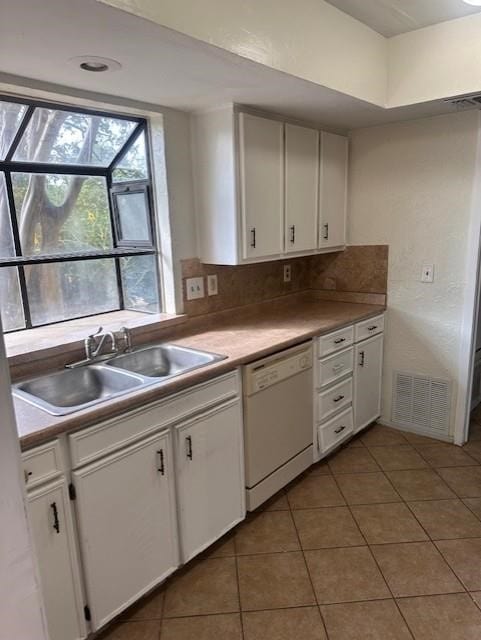 kitchen featuring light tile patterned floors, visible vents, a sink, dishwasher, and tasteful backsplash