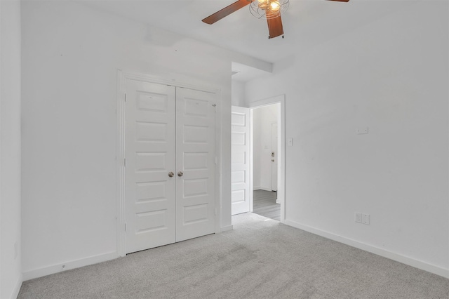 unfurnished bedroom featuring a closet, a ceiling fan, baseboards, and carpet floors