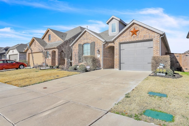 french country home with a front yard, a garage, brick siding, and driveway