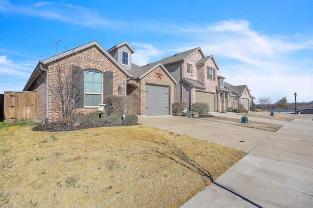 view of front of property featuring a front yard, a garage, brick siding, and driveway