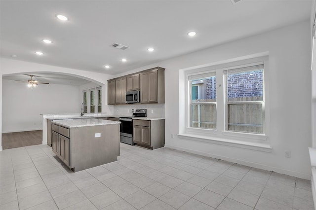 3917 Spencer Ln, Heartland, TX 75126 - kitchen featuring stainless steel appliances, arched walkways, a ceiling fan, a sink, and recessed lighting