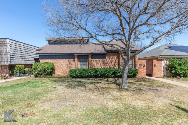 view of front facade with brick siding and a front lawn