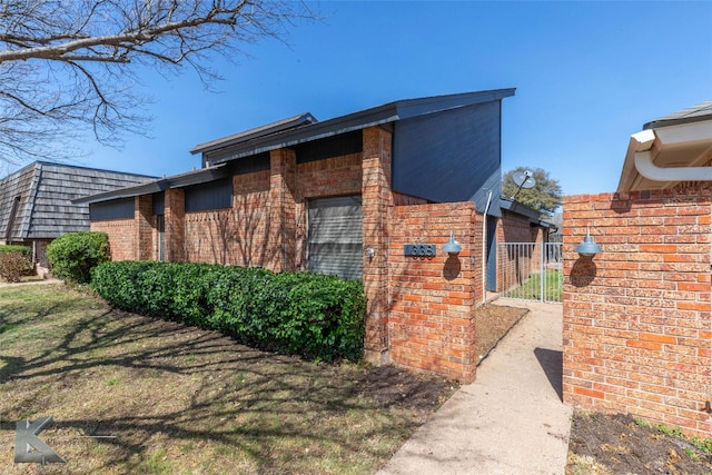 view of side of property with brick siding and a yard