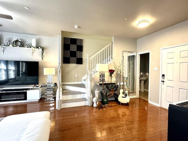 entryway featuring baseboards, wood finished floors, and stairs