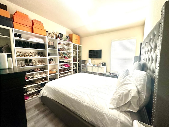 bedroom featuring lofted ceiling and wood finished floors