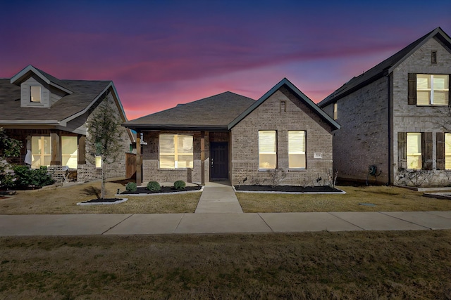 view of front of property featuring brick siding and a front lawn