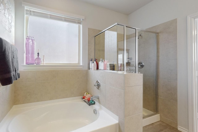 bathroom with a shower stall and a garden tub