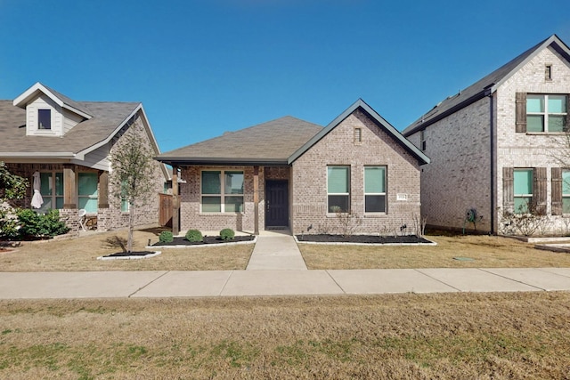 view of front of house featuring a front yard and brick siding