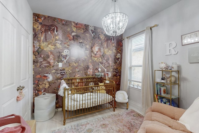 bedroom featuring wallpapered walls, a notable chandelier, and baseboards