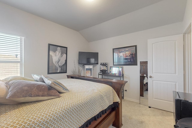 bedroom with light colored carpet, baseboards, and lofted ceiling